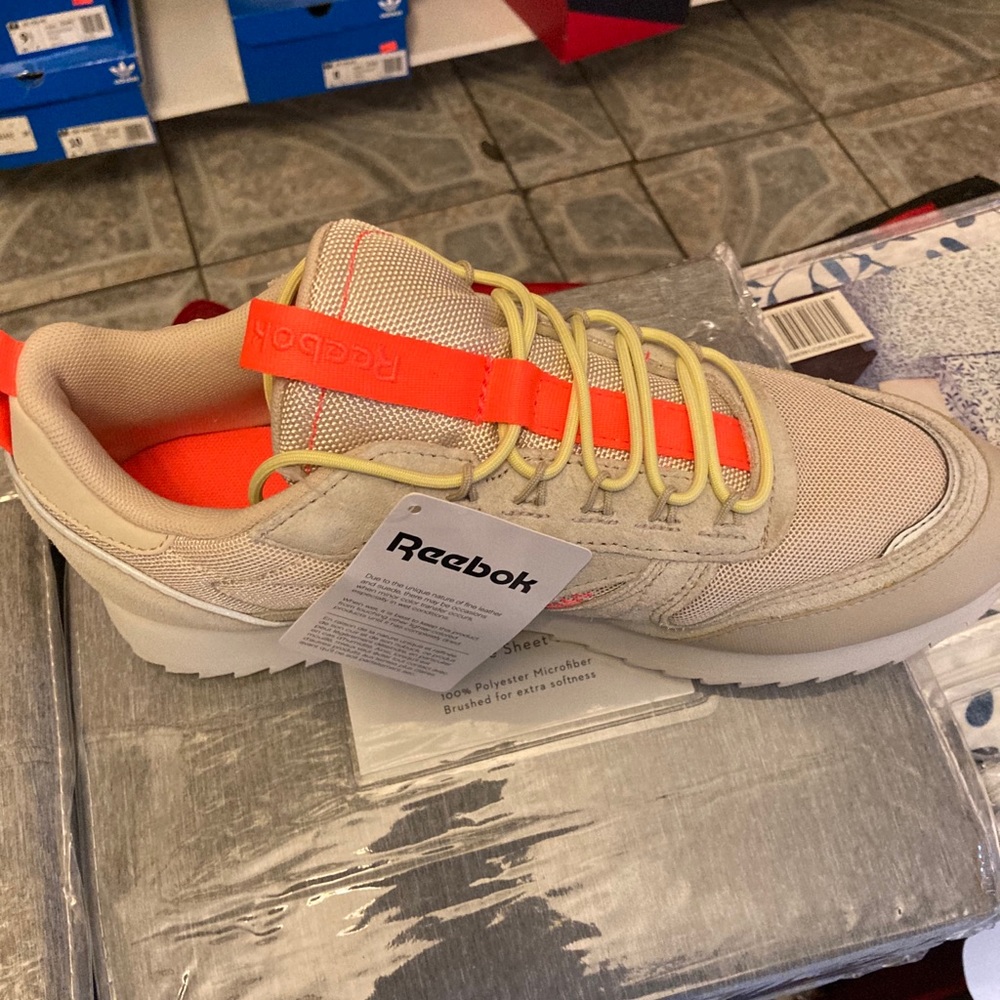 Light beige and orange Reeboks a woman